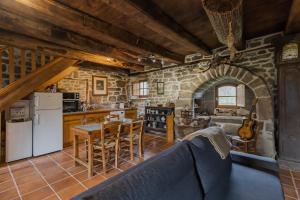 eine Küche und ein Esszimmer mit einer Steinmauer in der Unterkunft La maison de François in Chaumeil
