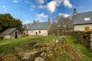 ein altes Haus auf einem Hügel mit einer Steinmauer in der Unterkunft La maison de François in Chaumeil