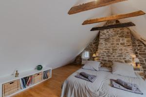ein Schlafzimmer mit einem Bett und einer Steinmauer in der Unterkunft La maison de François in Chaumeil
