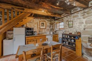 eine Küche mit einem Tisch und einem weißen Kühlschrank in der Unterkunft La maison de François in Chaumeil