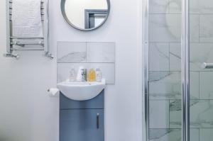 uma casa de banho com um lavatório e um espelho em Barton House - Sleeping 10 em Manchester