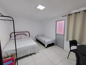 a bedroom with a bed and a chair and a window at KITNET EM OLINDA CASA CAIADA A 50 MT DA PRAIA in Olinda