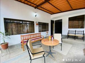 a patio with a table and chairs and a bench at Albreth - Hotel Bungalows in Huaraz
