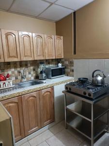 cocina con armarios de madera y horno con fogones en Albreth - Hotel Bungalows, en Huaraz