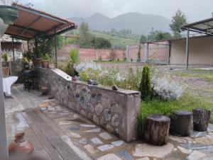 un jardín con una pared de piedra y algunas plantas en Albreth - Hotel Bungalows, en Huaraz