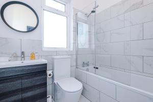uma casa de banho com um WC, um lavatório e um espelho. em Barton House - Sleeping 10 em Manchester