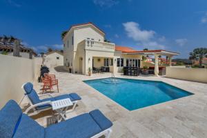 a villa with a swimming pool and patio furniture at Tierra Del Sol Resort & Golf in Palm-Eagle Beach
