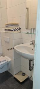 ein weißes Badezimmer mit Waschbecken und Toilette in der Unterkunft Ferienhaus Pauls Ferienhaus Pauls, Whg 07 in Norderney