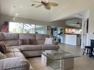 ein Wohnzimmer mit einer Couch und einem Glastisch in der Unterkunft Relax with nature in our Waterfront 4 bedroom -HEATED POOL HOME-KING BED in Cape Coral
