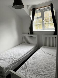 two beds in a small room with a window at 10 Wye Rapids Cottages in Symonds Yat