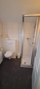 a bathroom with a toilet and a shower with a shower at Ferienhaus Pauls Ferienhaus Pauls, Whg 10 in Norderney
