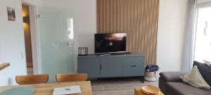 a living room with a flat screen tv on a dresser at Dünenrose Seegras Nr 41 in Norderney