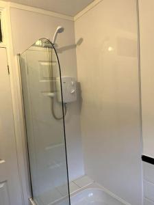 a bathroom with a shower with a glass door at 10 Wye Rapids Cottages in Symonds Yat