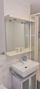 a bathroom with a white sink and a mirror at Dünenrose Seegras Nr 41 in Norderney