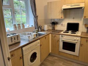a kitchen with a washing machine and a sink at 10 Wye Rapids Cottages in Symonds Yat