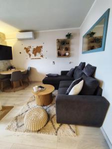 ein Wohnzimmer mit einer schwarzen Couch und einem Tisch in der Unterkunft My happy place in Poreč