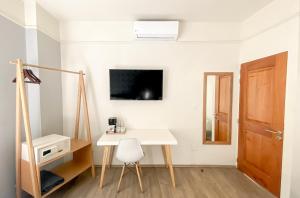 Zimmer mit einem Schreibtisch, einem TV und einer Tür in der Unterkunft Casa Condesa Michoacan 113 in Mexiko-Stadt