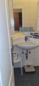a bathroom with a sink with a mirror and towels at Ferienhaus Pauls Ferienhaus Pauls, Whg 02 in Norderney