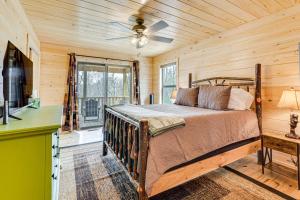 a bedroom with a bed in a room with wooden walls at Secluded Murphy Cabin Rental with Deck and Fire Pit! in Turtletown