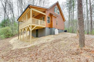 a wooden house in the middle of a forest at Secluded Murphy Cabin Rental with Deck and Fire Pit! in Turtletown