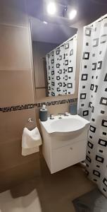La salle de bains blanche est pourvue d'un lavabo et d'un miroir. dans l'établissement Bello departamento zona centro, à Rosario