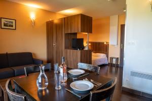 a room with a dining table and a living room at Résidence Château des Magnans by Nevesol in Jausiers