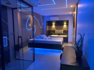 Schlafzimmer mit einem Bett und einer Glaswand in der Unterkunft Up Motel in Ribeirão Preto