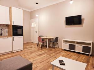 a living room with a kitchen and a table with chairs at Justinrent 3 in Legnica