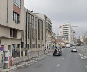 Una calle de la ciudad con coches conduciendo por la calle en Appartement au Pied du Metro Mairie de Clichy L13, en Clichy 4 fotos más