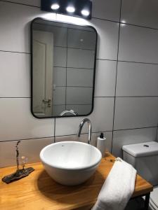 ein Badezimmer mit einem weißen Waschbecken und einem Spiegel in der Unterkunft Twin peaks in El Calafate