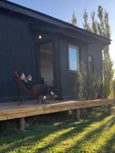 a woman sitting in a chair on a porch of a house at Twin peaks in El Calafate