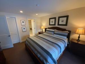 una camera da letto con un letto grande con due lampade e quadri sul muro di Beautiful First Floor suite with patio to the Bay a Traverse City Altre 12 foto