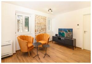 a living room with two chairs and a tv at House Gambin in Primošten