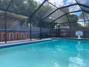 a swimming pool with a tent and a basketball hoop at Backyard oasis family fun! in St Petersburg