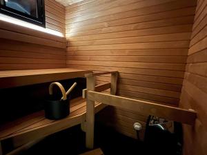 a wooden sauna with a bench and a bucket at Holiday Home Rakkaranta b- lentäjän poika 2 by Interhome in Hyrynsalmi