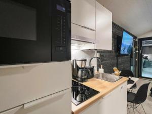 een keuken met een wastafel en een fornuis top oven bij Holiday Home Rakkaranta c- henry ford cabin two skipa by Interhome in Hyrynsalmi
