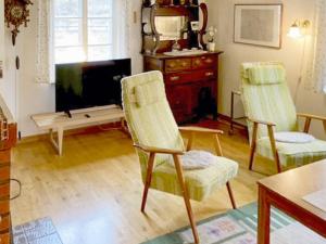 a living room with two chairs and a tv at Idyllic Getaway with Private Beach in Abbetorp