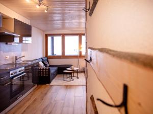eine Küche und ein Wohnzimmer mit einem Sofa in der Unterkunft Apartment Les Chavonnes by Interhome in Gryon