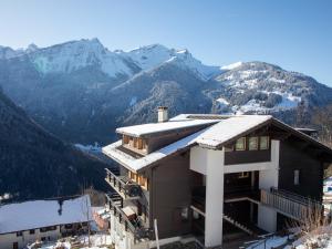 uma casa nas montanhas com neve no telhado em Apartment Les Chavonnes by Interhome em Gryon