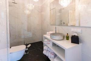 a bathroom with a sink and a toilet and a tub at Kaleo apartments - Hanza Tower in Szczecin