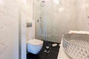 a bathroom with a shower and a toilet and a sink at Kaleo apartments - Hanza Tower in Szczecin
