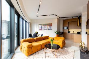 a living room with a yellow couch and a table at Kaleo apartments - Hanza Tower in Szczecin