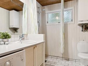 a bathroom with a sink and a toilet at Holiday Home Swenki - all inclusive - 700m from the sea by Interhome in Saltum