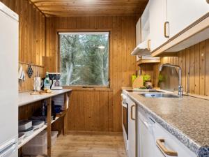 kuchnia z drewnianymi ścianami i oknem w obiekcie Holiday Home Swenki - all inclusive - 700m from the sea by Interhome w mieście Saltum