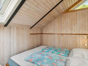 um pequeno quarto com uma cama num sótão em Holiday Home Benja - all inclusive - 150m from the sea by Interhome em Knebel