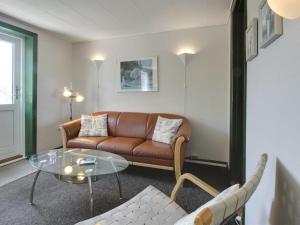 een woonkamer met een bank en een glazen tafel bij Apartment Withar - all inclusive - 800m from the sea by Interhome in Fanø