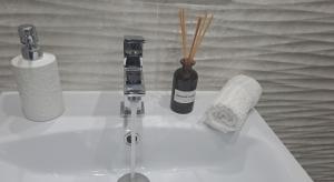 a bathroom sink with a bottle of soap and a toothbrush at Homestay near motorway in Giarmata