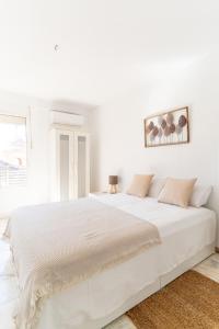 1 dormitorio blanco con 1 cama blanca grande en TrendyHomes San Sebastián, en Almería