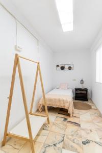 una habitación blanca con una cama y una mesa en TrendyHomes San Sebastián, en Almería