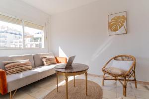 a living room with a couch and a laptop on a table at TrendyHomes San Sebastián in Almería